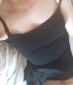 A person in a black bra and white shirt, close-up of chest and upper body.