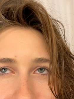 Woman with light brown hair and green eyes looking up from a low angle.