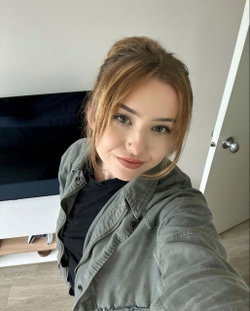 Woman with shoulder-length brown hair in a casual jacket and black shirt.
