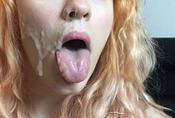 Redhead with messy hair and cream on face sticking out tongue.