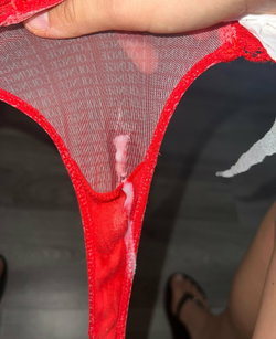 Person in a red mesh top with white trim, close-up of chest area.