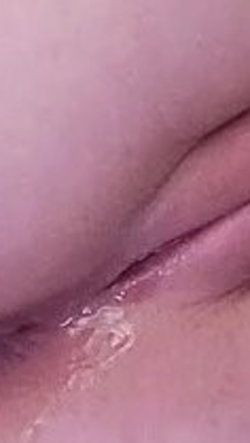 Macro photograph capturing soft pink skin folds with glistening moisture on the surface.