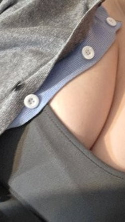 Close-up of a person's chest with a gray top partially unbuttoned, revealing skin and a blue undershirt.