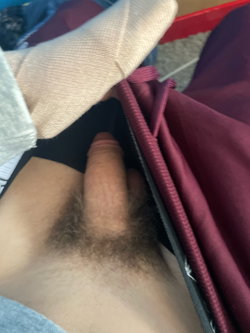 Person with light skin tone lying under a plaid blanket.