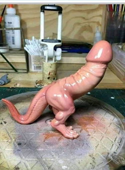 A pink silicone dinosaur figurine with a large phallic protrusion, placed on a workbench with crafting tools and