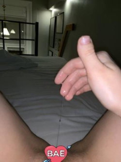 Close-up of a person's hands and legs on a bed, with a heart sticker over the crotch area; indoor bedroom setting.