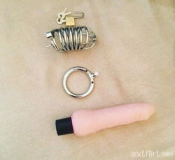 Sex toys including a metal cage, ring, and pink vibrator arranged on a beige surface.