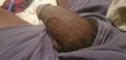 A person's foot is visible under a purple blanket on a bed.