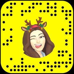 Woman with long brown hair wearing a reindeer headband and smiling.