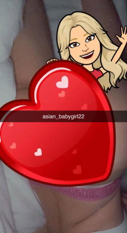 A person with light-colored hair lies on a bed, wearing purple underwear, partially obscured by a large red heart