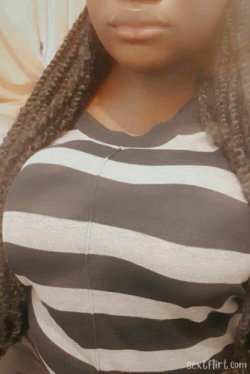 Woman with long braided hair wearing a black and white striped top, shown from chest up in a close-up shot.