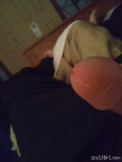 Close-up of a foot in the foreground, with a person wearing dark pants and light-colored underwear lying on a wooden