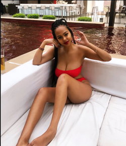 A curvy woman in a red bikini lounges by a pool.